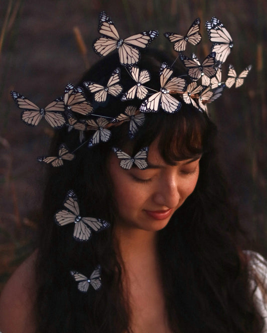 Woman wearing a headpiece with butterfly decorations in a natural setting
